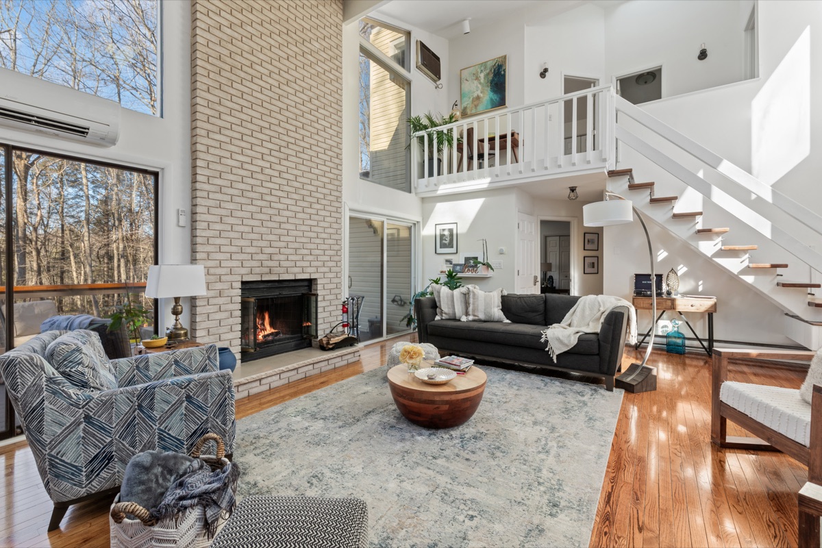 Open-concept living area with panoramic windows, high ceilings, and a bright, welcoming vibe.