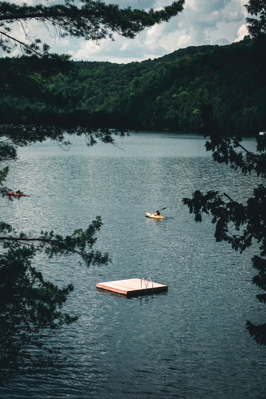 Breathtaking lake scenery with kayakers and floating dock in Mont-Tremblant, perfect for nature enthusiasts.