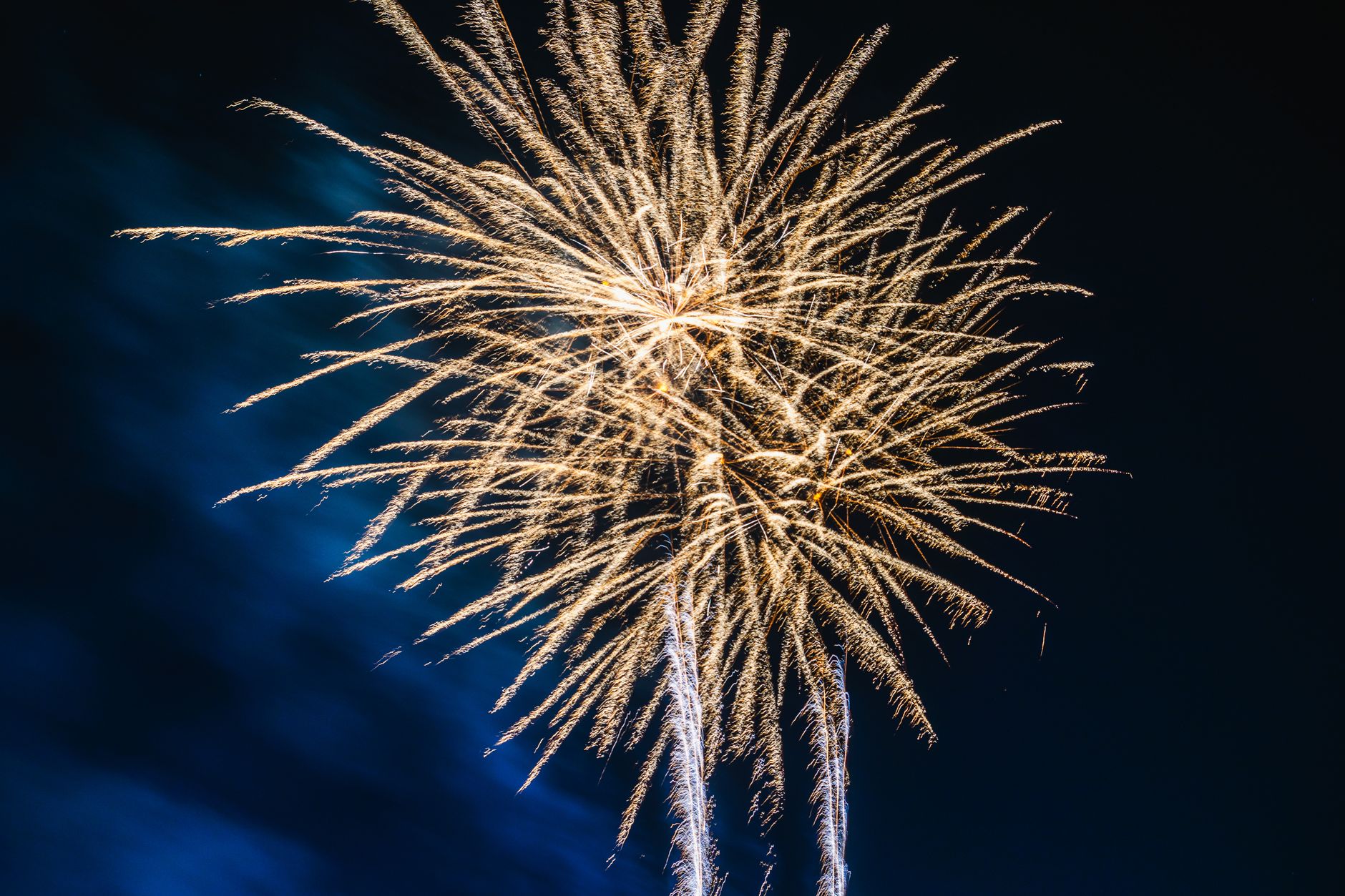 Bright fireworks lighting up a clear night sky during a festive celebration.