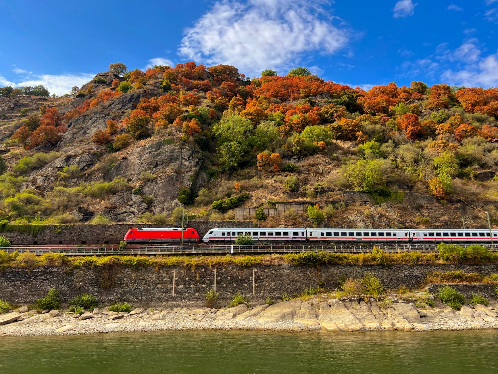 Train travels through Oberwesel's autumn landscape along the Rhine River.